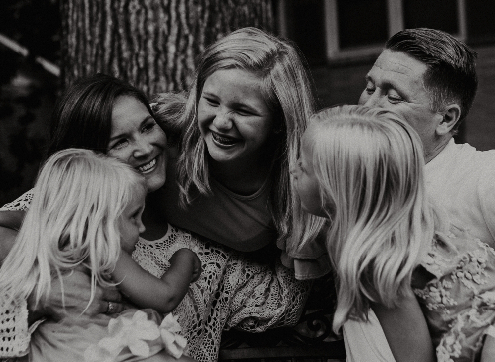 Family of five all looking an laughing at each other